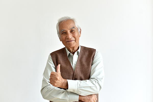 Senior man smiling at the camera and giving a thumbs-up