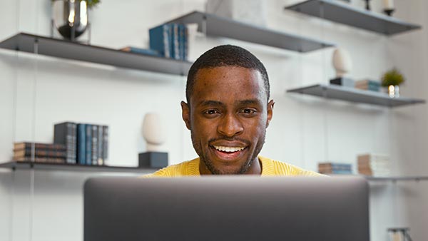 Man using his laptop to look up, ‘Can term life insurance be converted to whole life?’