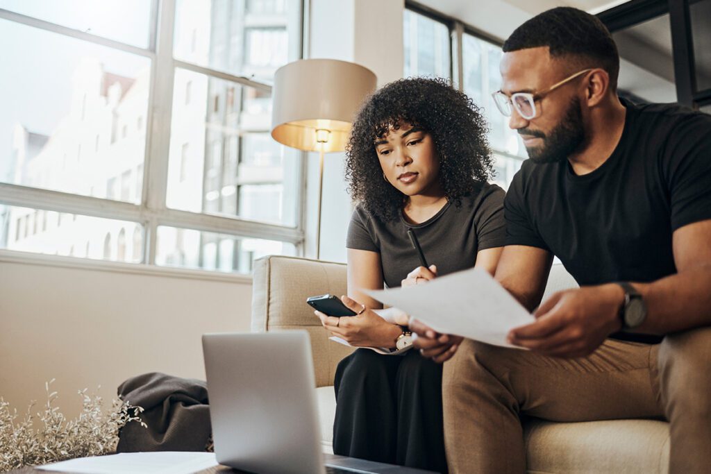 A couple researches how to enroll in health insurance on their laptop