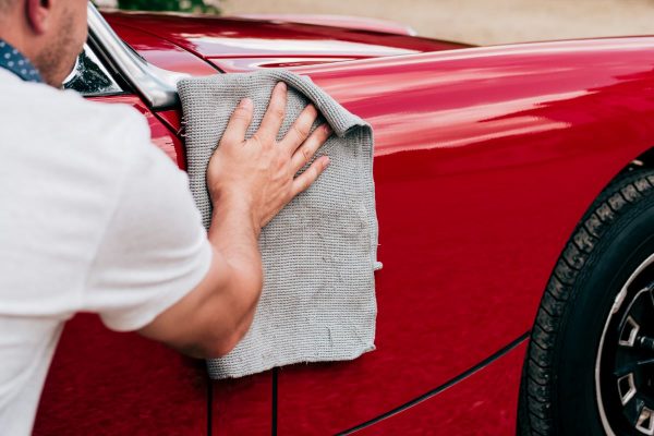 Classic car owner polishing MG Midget