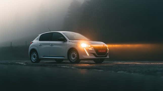 Front 3/4 view of a white Peugeot 208 Rallye in the fog