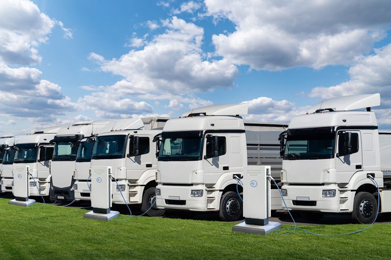 Row of electric semi trucks at charging stations