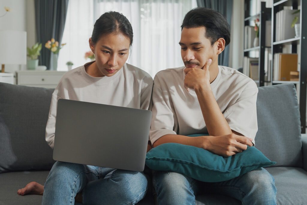 A young couple compares health insurance options online.