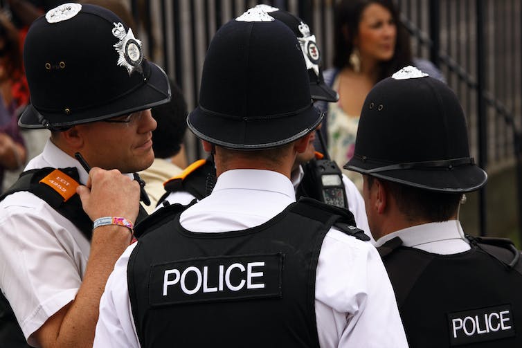 A group of four police in uniform, with distinctive bell shaped hats