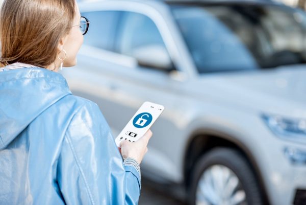 Woman unlocking car using a smartphone app