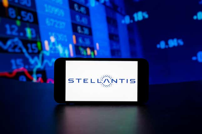 Stellantis logo is seen displayed on a mobile phone screen with stock market percentages in the background