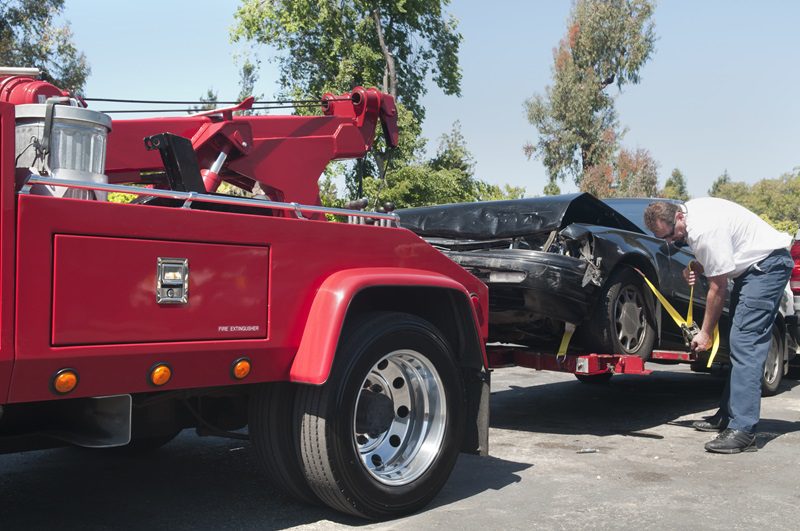 Tow Truck Driver Hauling a Wrecked Car