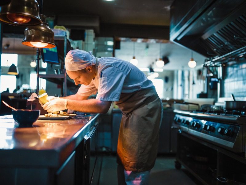 Chef serving food in the modern kitchen in a high-end restaurant