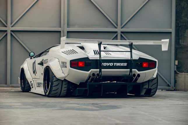 Rear 3/4 view of a white Lamborghini Countach with a Liberty Walk body kit