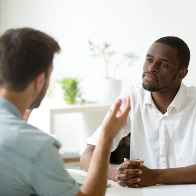 Two men talking. One looks puzzled.