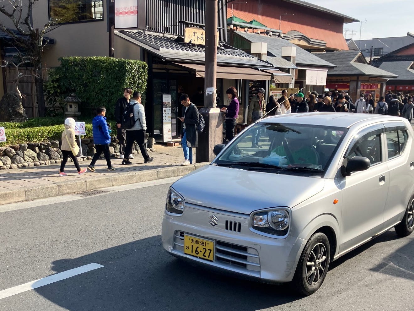 A Suzuki Alto on a busy road in Japan