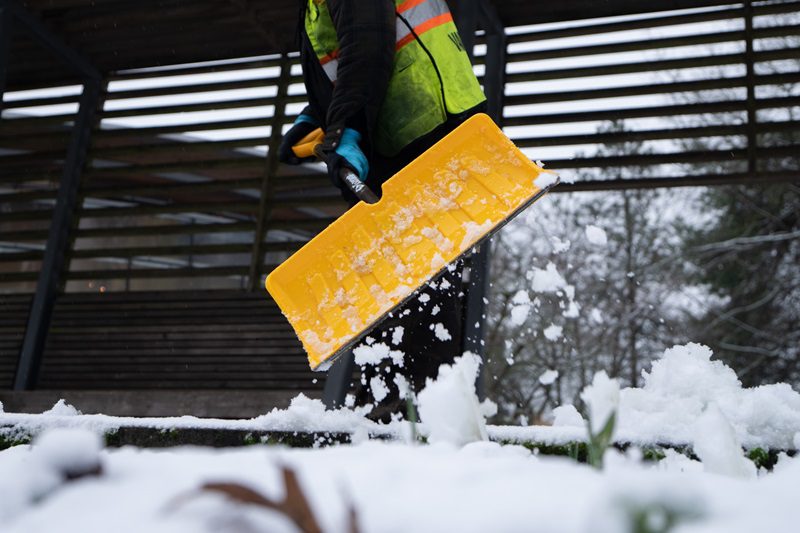 A city worker shovels snow in Vancouver