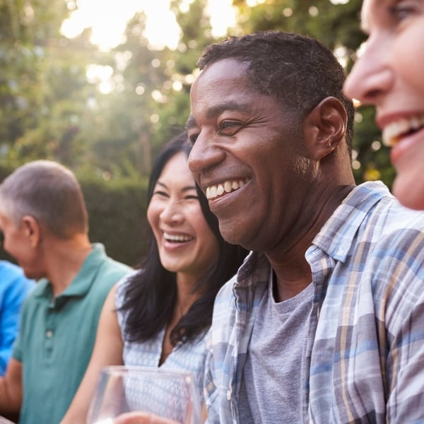 A mature couple laughing outdoors.