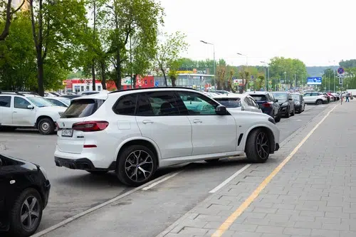 white car driving over pavement