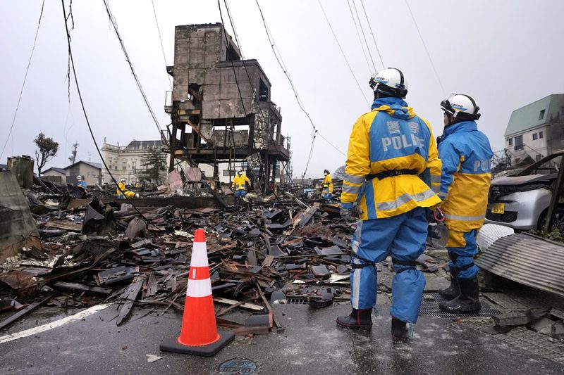 Emergency responders looki on at earthquake damage