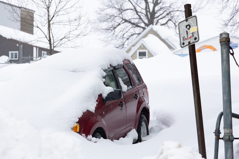 A vehicle buried under snow following a winter storm