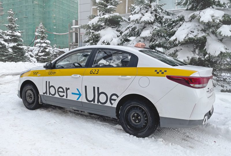 Taxi car with Uber logo on the snowy street.