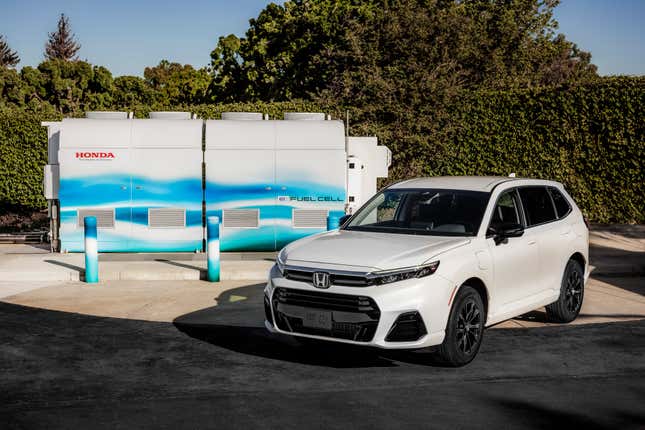 Front 3/4 view of a white 2025 Honda CR-V e:FCEV in front of a hydrogen generator station