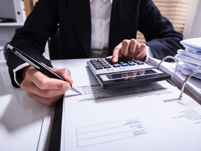 Desk adjuster using calculator with bills on a desk