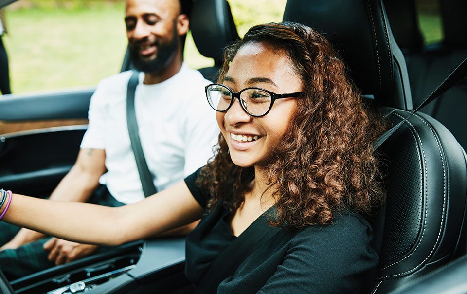 Teen girl driving car with an adult in the passenger seat.