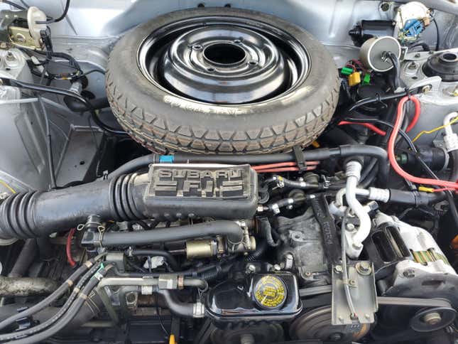 An underhood shot of the loyale's engine and the spare tire