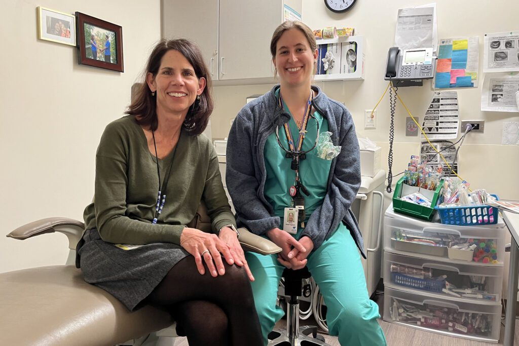 Pediatrician Patricia Braun (left) and Valerie Cuzella (right) sit side by side in a dental exam room.