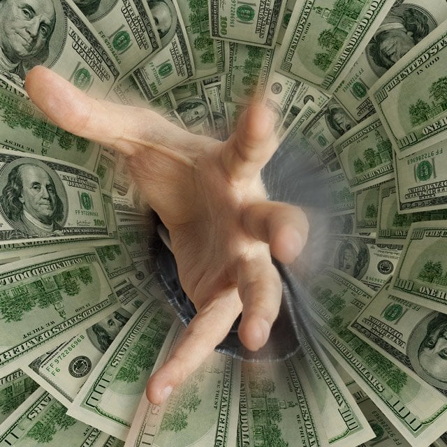 Hand reaching out of money pit