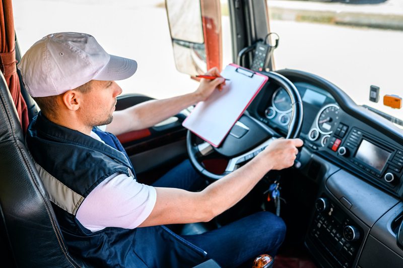 Professional truck driver driving truck vehicle going for a long transportation route.