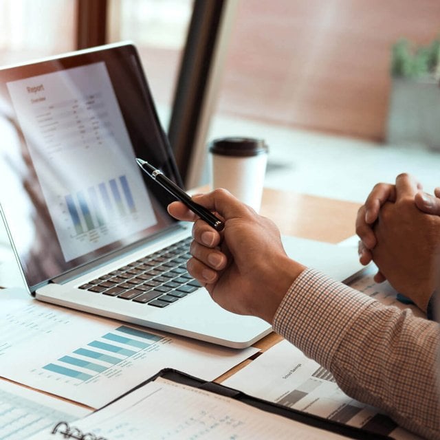 hand pointing at a laptop screen with pen - asset allocation chart