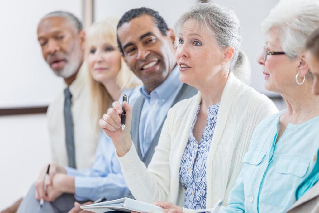 A woman asks a question during a Medicare seminar