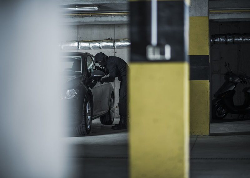 Car thief trying to steal modern compact vehicle.