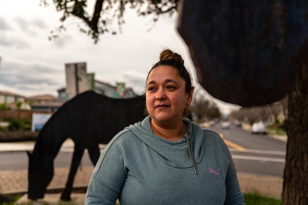 A photo of a woman standing outside for a portrait.