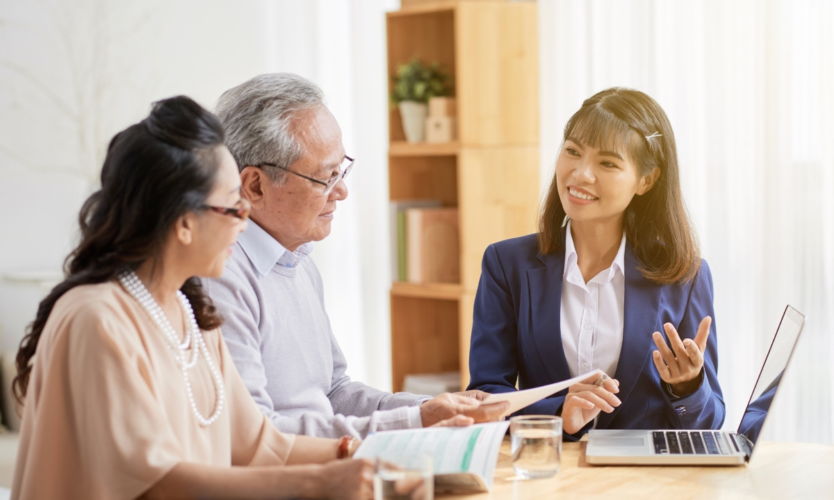 an adult couple talking to an insurance broker