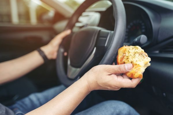 Person eating food while trying to drive