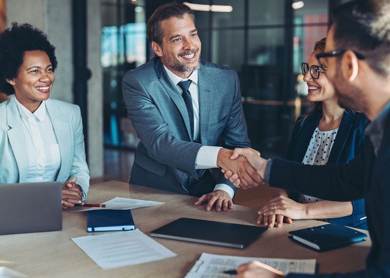 Businessmen shaking hands across the table