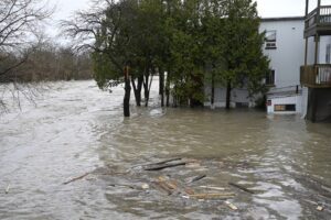 Flood waters surrounding a home following a 2023 flood in Baie Saint-Paul, Que.