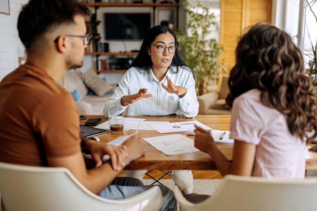 Young couple listening to their insurance broker explain their policy