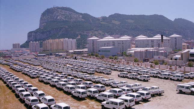 A photo of a field full of white Toyota trucks in Gibraltar. 