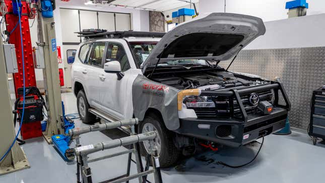 A photo of a white Toyota truck in a workshop. 