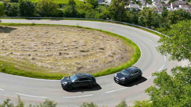 Two camouflaged Porsche Cayenne EV prototypes going around a corner