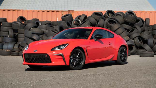 A 2023 Toyota GR86 parked in front of a pile of tires.