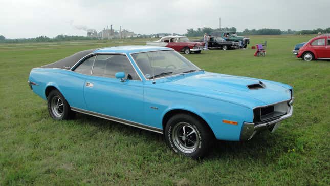 A 1970 AMC Javelin SST model, a two-door hardtop (no B-pillar) pony car finished in American Motors' special "Big Bad Blue" paint code: 2A, with optional half vinyl roof in black.