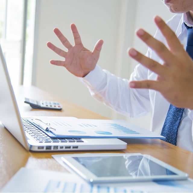 Businesman gesturing angrily in front of computer during outage of banking website