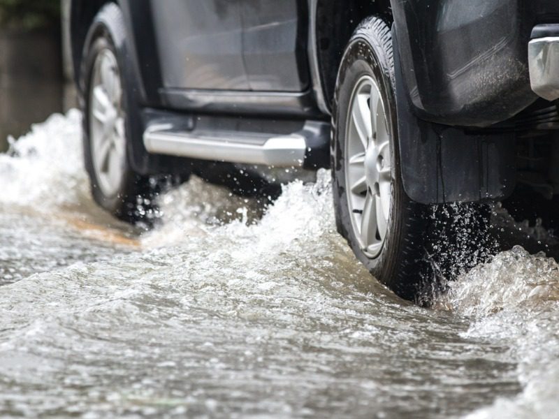 Truck drives through flooded street