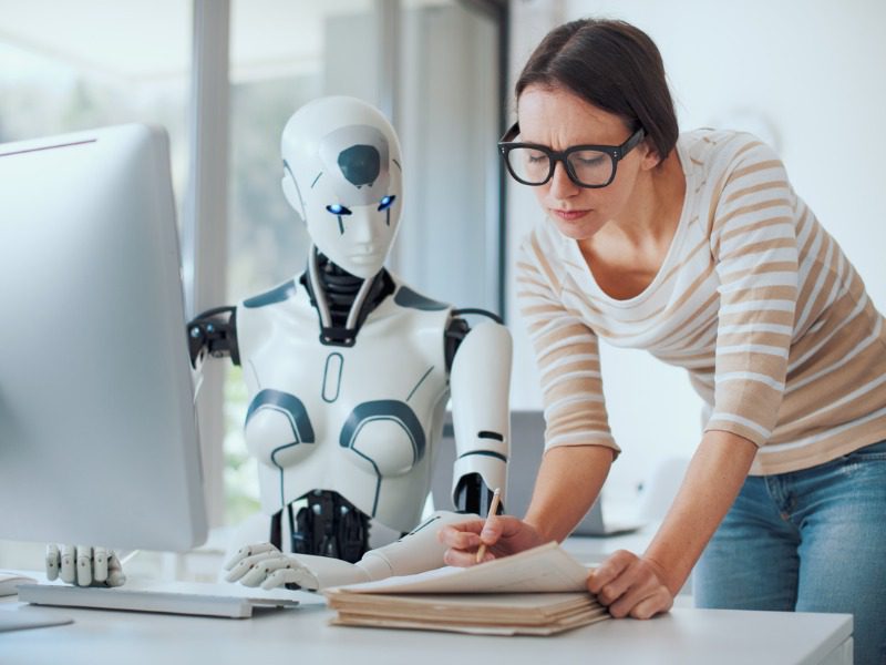 Woman and AI robot working together in the office