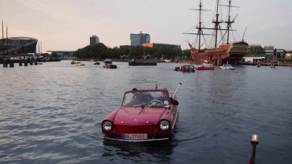 100 amphibious cars glide through Amsterdam's canals on a final float for a while