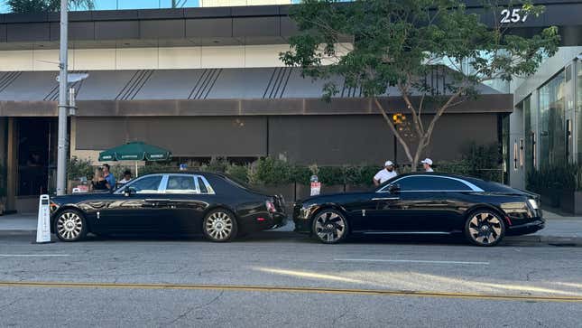 Side view of a black Rolls-Royce Phantom parked in front of a black Rolls-Royce Spectre