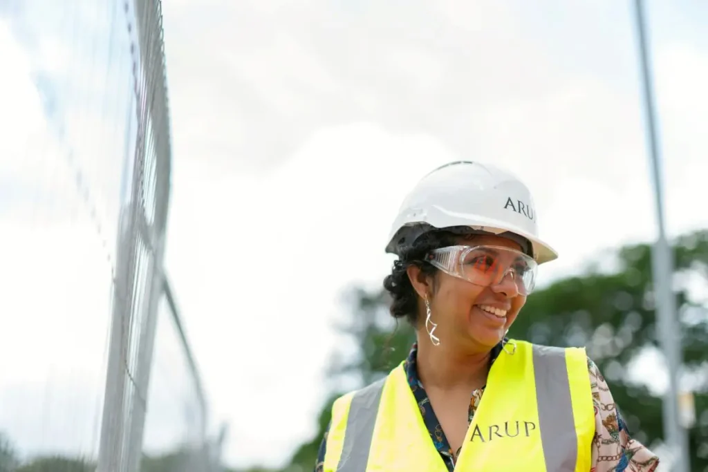 Female civil engineer on site smiling at someone off camera