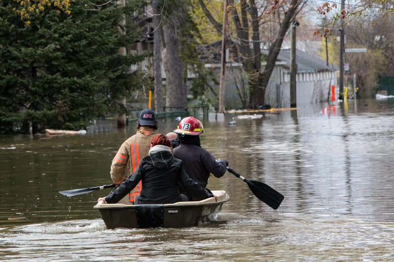 Fireman rescue an old couple from their flooded house with a boat. On Cousineau St., in the Ahuntsic-Cartierville borough, Montreal, the river rose and flooded the street and a dozen of houses.