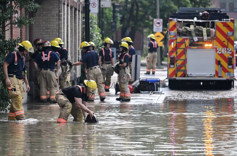 Firefighters remove a manhole cover following a watermain break on a street in Montreal, Friday, August 16, 2024, causing flooding in several streets of the area. Cleanup is underway after a major water main break near Montreal's Jacques Cartier Bridge flooded dozens of buildings on Friday and left nearly 150,000 people under a boil-water advisory. THE CANADIAN PRESS/Graham Hughes